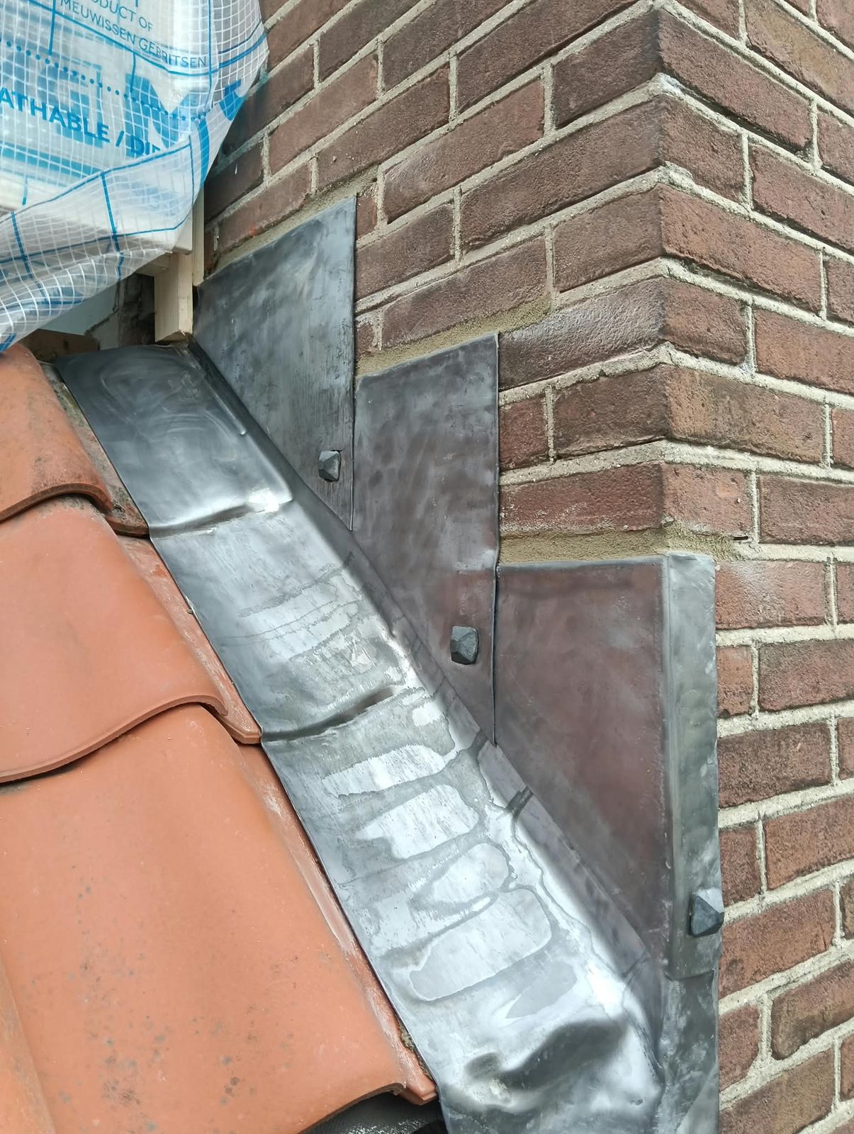 Nieuw loodwerk bij een dakaansluiting