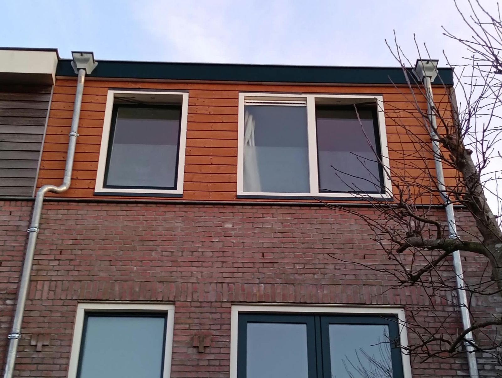 Opbouw met houten gevelbekleding en nieuwe ramen